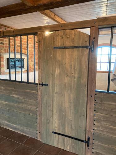 a wooden barn door in a room with windows at Stallet på Skårby in Ystad