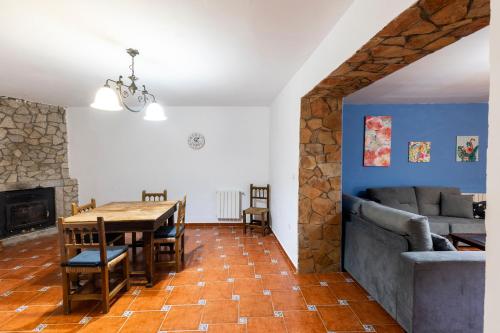 Casa Rural El Abeto في Torre de Don Miguel: غرفة طعام وغرفة معيشة مع طاولة وأريكة