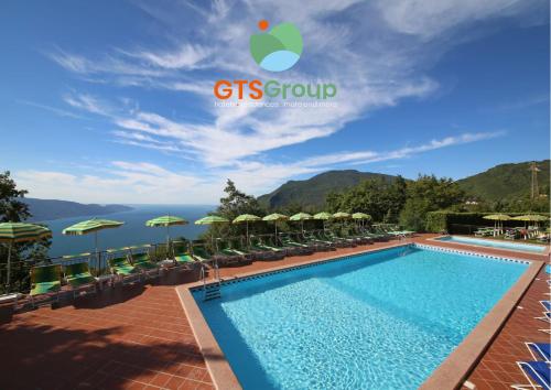 einen Pool in einem Resort mit Stühlen und Sonnenschirmen in der Unterkunft Hotel Residence Panorama La Forca, GTSGroup in Tignale