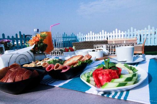 uma mesa com pratos de comida e uma bebida em Euro Homes Hotel em Acra