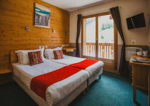 ein Schlafzimmer mit einem großen Bett und einem Fenster in der Unterkunft Hôtel Les Grangettes in Méribel