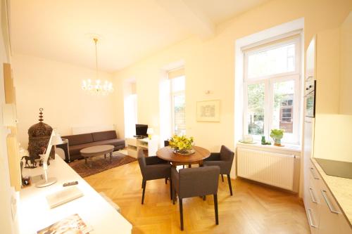 cocina y sala de estar con mesa y sillas en Hoheschule Apartment Levade, en Viena