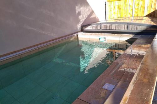 una piscina vuota con un bordo libero e un ponte coperto di Le Grand PIerron Clarée Valley cosy apartment in mountain, 6p a Val-des-Prés