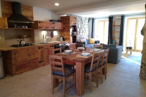 Il dispose d'une cuisine et d'un salon avec une table et des chaises en bois. dans l'établissement Le Grand PIerron Clarée Valley cosy apartment in mountain, 6p, à Val-des-Prés