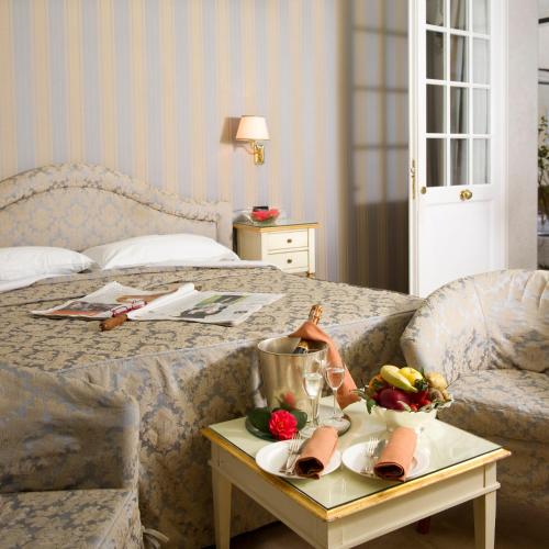 a hotel room with a bed with a tray of food on a table at Hotel Carlton On The Grand Canal in Venice