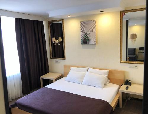 een hotelkamer met een bed en een spiegel bij Hotel Elista in Elista