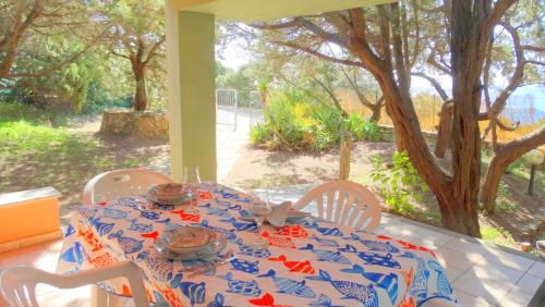 a table with chairs and a table cloth with food on it at Villa dell'Arte Vista Mare in Villasimius