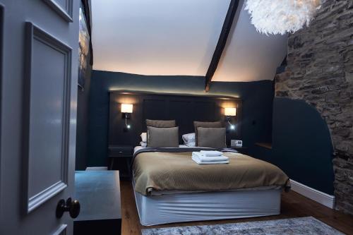 a bedroom with a large bed with blue walls at The Brown's Hotel in Laugharne