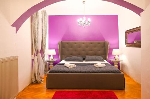 sypialnia z fioletowymi ścianami i dużym łóżkiem w obiekcie Breathtaking Suite Mozart w Wiedniu
