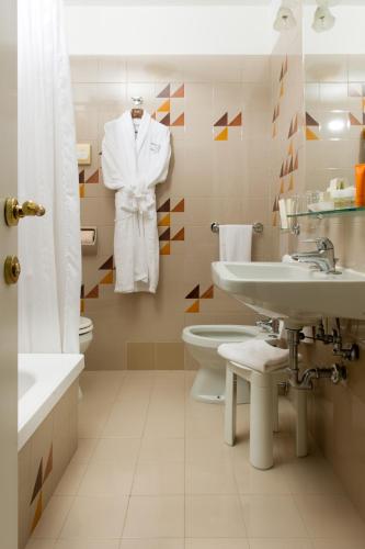 a white bathroom with a sink and a toilet at Hotel Carlton On The Grand Canal in Venice