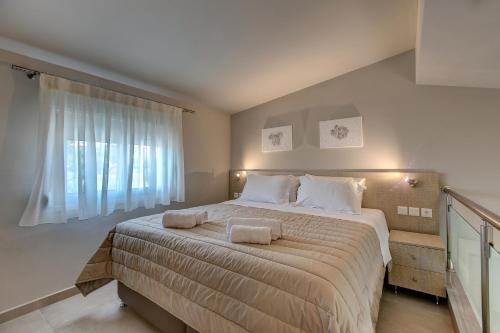 a bedroom with a large bed with two towels on it at The House Of The Roses in Yerakiní