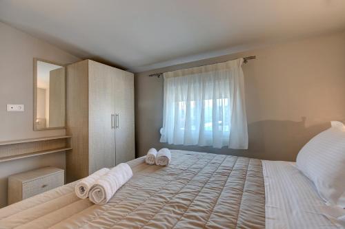 a bedroom with a large bed with towels on it at The House Of The Roses in Yerakiní