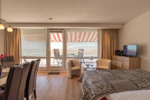 een hotelkamer met een bed en uitzicht op een balkon bij Ferienwohnung Backbord in Schilksee