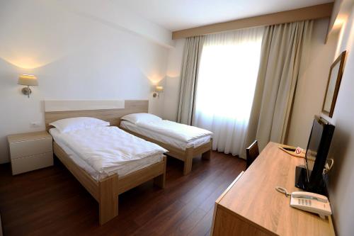 a hotel room with two beds and a television at Hotel Quercus in Međugorje