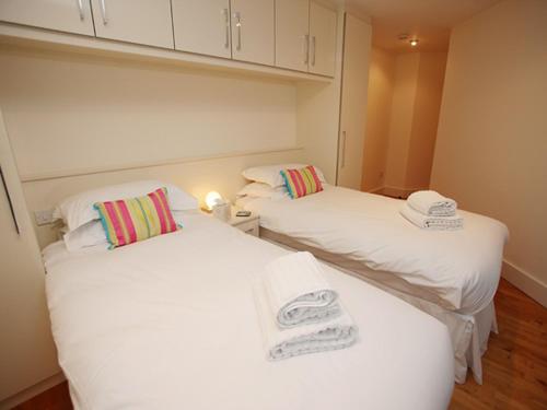 dwa łóżka w pokoju z białą pościelą i ręcznikami w obiekcie Marina Secret w Poole