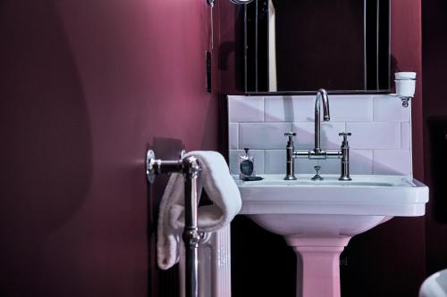 a bathroom with a white sink and a mirror at The Brown's Hotel in Laugharne