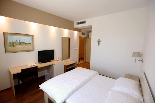 a bedroom with a bed and a desk with a computer at Hotel Quercus in Međugorje