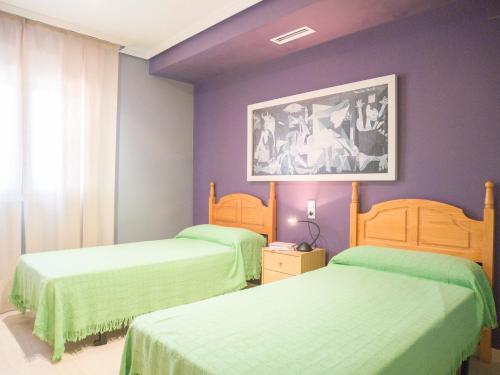 アルコセブレにあるVILLA CHALET CAP I CORPのベッドルーム1室(緑のシーツと紫の壁のベッド2台付)