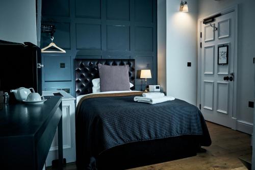 a bedroom with a bed with a black headboard at The Brown's Hotel in Laugharne