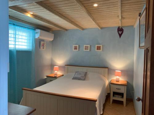 a bedroom with a bed and two lamps on tables at Cozy apartment with beach at walking distance and pool in Dickenson Bay