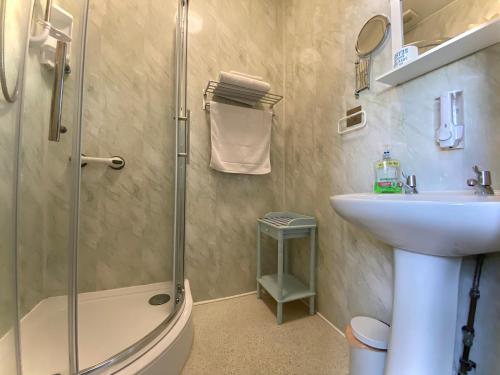 uma casa de banho com um chuveiro, um lavatório e um WC. em Cumbria Guest House em Lytham St Annes