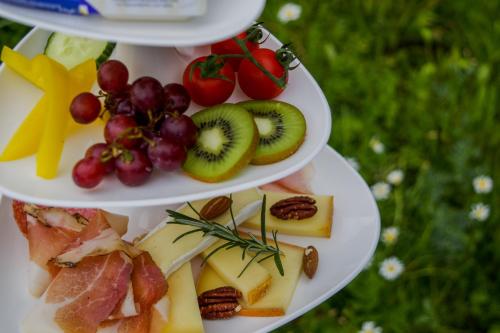 a three tiered plate of food with fruit and vegetables at Garni Soldanella in Samnaun