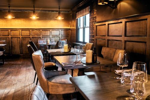 a restaurant with wooden walls and tables and chairs at The Brown's Hotel in Laugharne