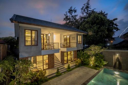 a house with a swimming pool in front of it at Ranggen Ubud in Ubud