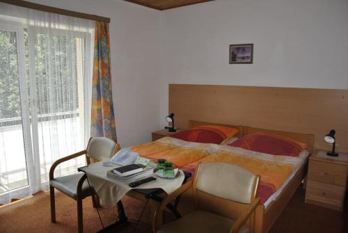 1 dormitorio con 1 cama y 1 mesa con sillas en Gasthof und Pension Haunschmid, en Rechberg