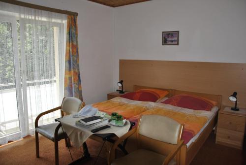 Schlafzimmer mit einem Bett und einem Tisch mit Stühlen in der Unterkunft Gasthof und Pension Haunschmid in Rechberg