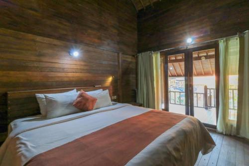 珀尼达岛Waterside inn Nusa Penida的一间带床和大窗户的卧室