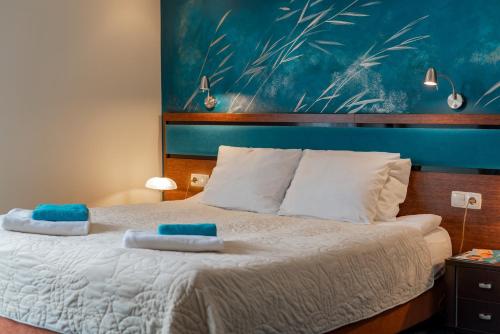 a bedroom with a bed with two towels on it at Hotel Willa Złota in Karwia