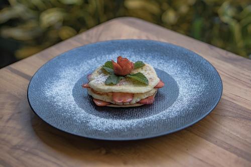 a blue plate with a sandwich with a strawberry on it at Ranggen Ubud in Ubud