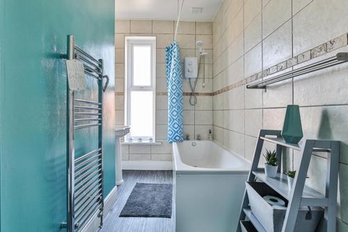 a blue bathroom with a tub and a shower at Heart of the City-Flexi Cancellations-Central Hub in Sheffield