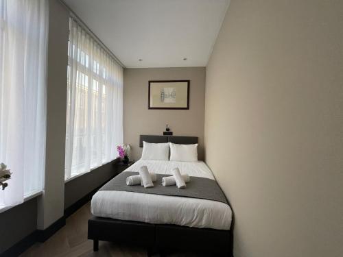 a bedroom with a large bed with two pillows at H3 Hotel Rotterdam City Center in Rotterdam