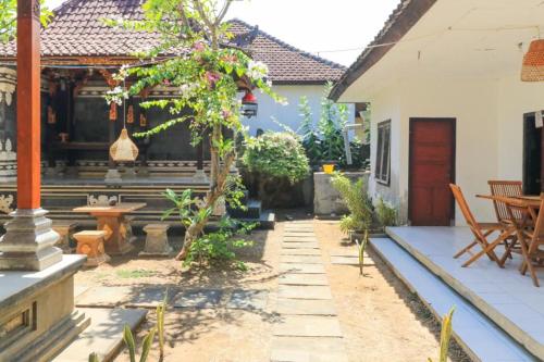 a courtyard of a house with a table and chairs at Waterside inn Nusa Penida in Nusa Penida