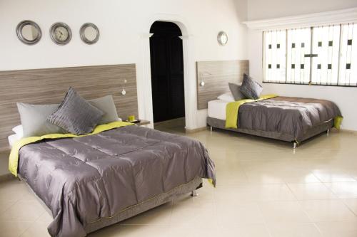 a bedroom with two beds and a large window at HOTEL Premium House in Floridablanca