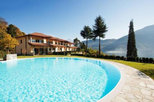 a large swimming pool in front of a house at Tremezzo Residence 3-1 of 11 apartments in an exclusive residence by Italian Apartments in Tremezzo