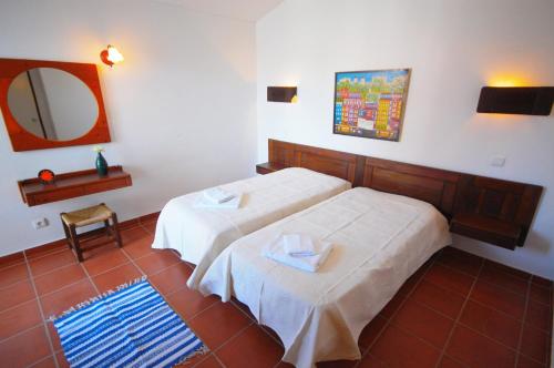 ein Hotelzimmer mit 2 Betten und einem Spiegel in der Unterkunft Villa Jacaranda - 550m from the beach - Free WIFI - By Bedzy in Albufeira