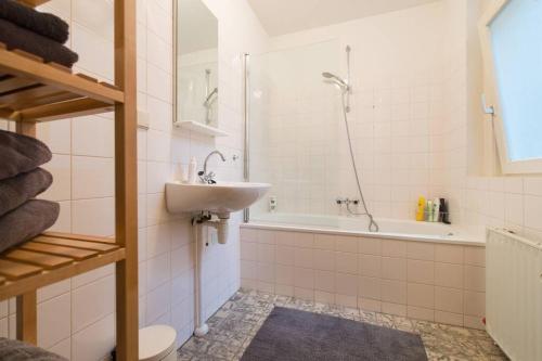 uma casa de banho com um lavatório, um chuveiro e uma banheira em Charming apartment in city center em Amesterdão