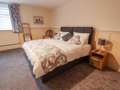 a bedroom with a large bed and a night stand at 3 Springhaven in Harrogate