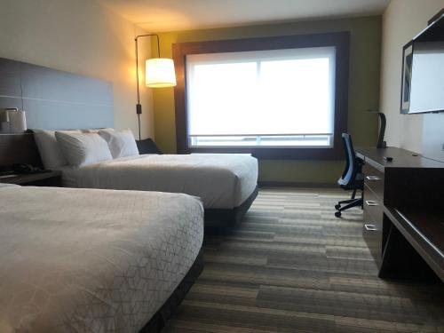 a hotel room with two beds and a flat screen tv at Holiday Inn Express & Suites - Madison West - Middleton by IHG in Middleton