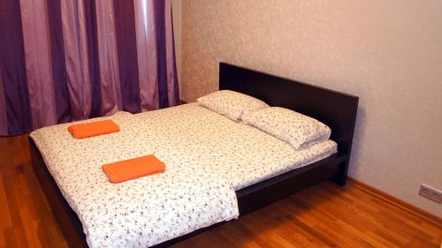 モスクワにあるApartment Na 3ey Marinoy Roshiのベッド1台(上にオレンジの枕2つ付)