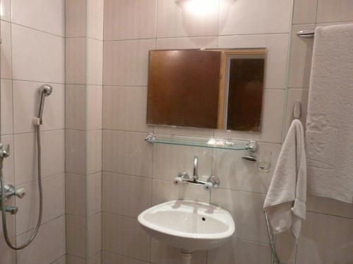 ein Badezimmer mit Waschbecken und Dusche mit Fenster in der Unterkunft Family Hotel Balchik in Baltschik