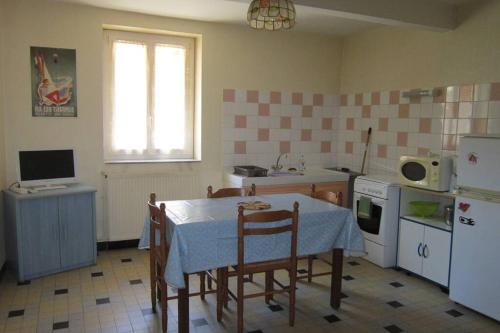 une cuisine avec une table et une cuisine avec une table et des chaises dans l'établissement Appartement RDC maison de village, à Savignac-les-Ormeaux