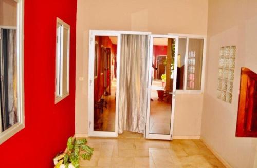 um quarto com paredes vermelhas e um corredor com espelhos em CHAMBRES CLIMATISÉES EN VILLE em Saint-Louis