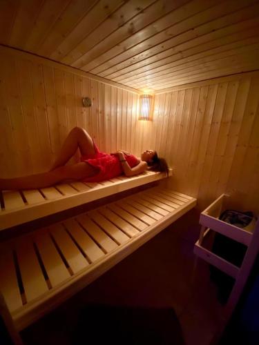 a woman is laying in a sauna at RELAX PENZIÓN J&L in Pavčina Lehota