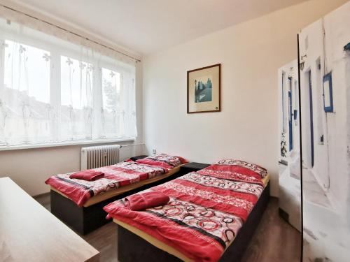 two beds in a room with a window at byt s balkonem in Žatec