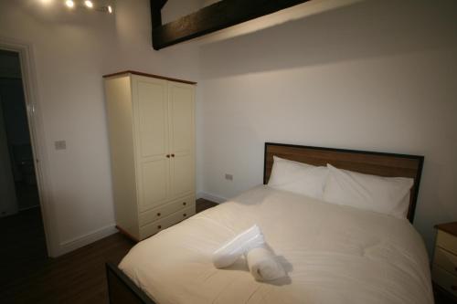 a bedroom with a bed with a white pillow on it at Flat 5, 124 High Street in Newmarket