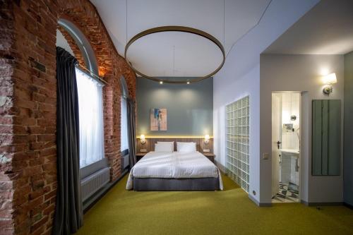 a bedroom with a bed and a brick wall at Four Rooms City in Kharkiv
